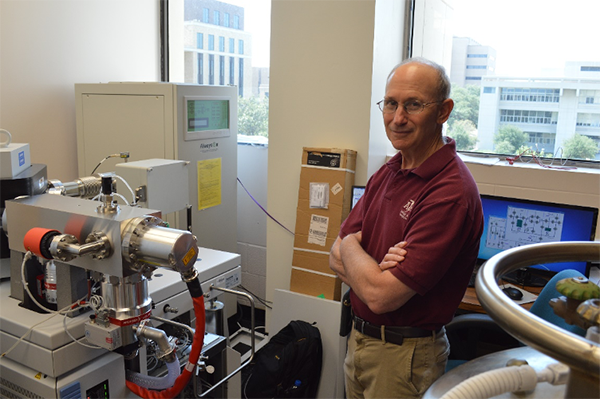 Dr. Grossman with the mass spectrometer used for clumped isotope analyses. (Photo courtesy of Grossman.)