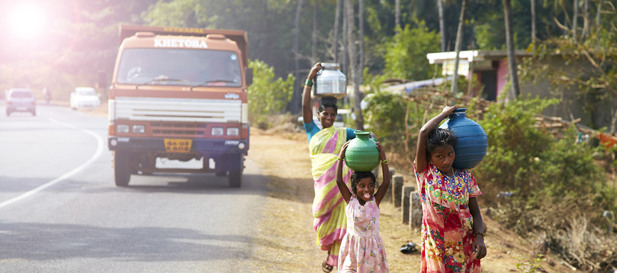 A woman and children carrying water on their heads in traditional pots in rural India. (Photo credit: iStock.)