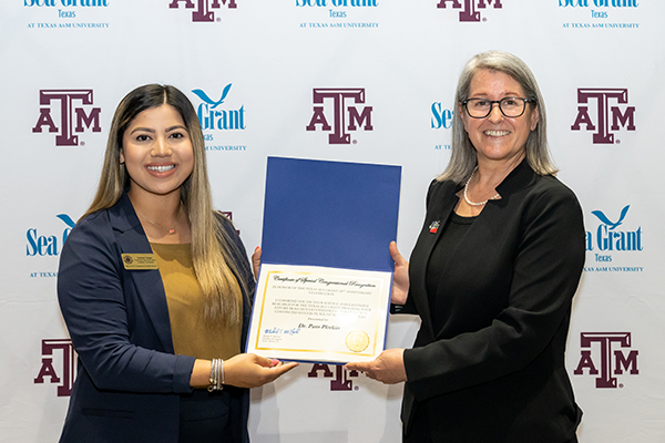 Destinee Vargus from the Office of U.S. Congressman Michael McCaul (left) and Dr. Pamela Plotkin with the Certificate of Special Congressional Recognition (Photo credit: Richard Badillo)