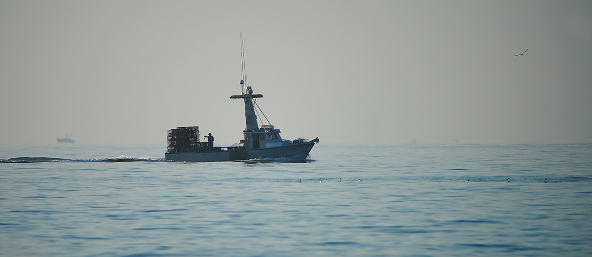 A crab fishing boat patrols the morning hours off the shores of Huntington Beach, California. (Getty images.)