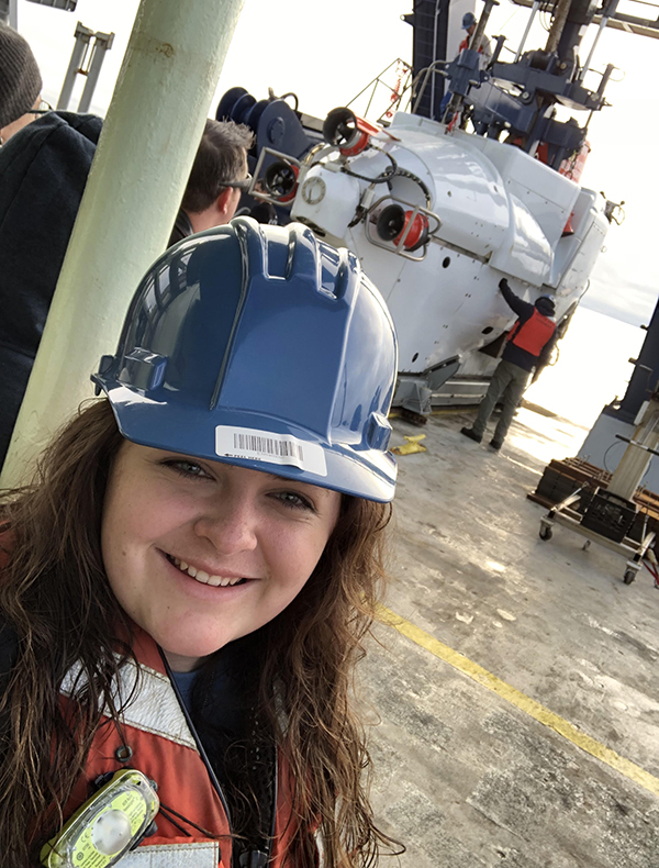 Self aboard the R/V Atlantis, with HOV Alvin. (Photo courtesy of Mia Self.)