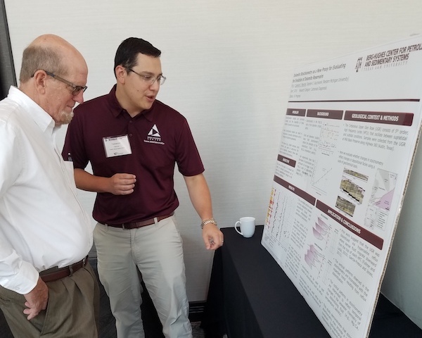 Geology and geophysics professor Dr. Mike Pope and postdoctoral research associate Dr. Cameron Joseph Manche discuss the details of a research poster at the Berg-Hughes 10th annual Research Symposium. (Photo by Ali Snell.)