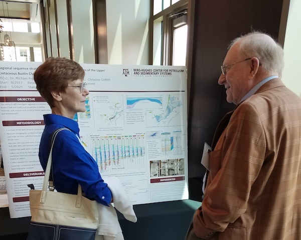 Geology and geophysics Ph.D. student Christine Griffith discusses her research poster with a symposium participant. (Photo by Ali Snell.)
