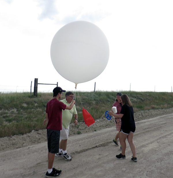 Dr. Conlee and students launch a weather balloon during a previous project. Photo courtesy of Dr. Chris Nowotarski.