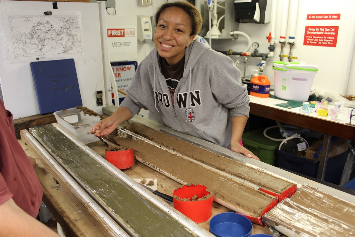 Dr. Bryant examining a piston core from the shelf area off the coast of southern California while serving as a gradaute mentor with the program STEM SEAS. In the summer of 2016, STEM SEAS sailed from San Diego, California to Honolulu, Hawaii with 10 undergraduate students from various institutions and majors, all of whom were interested in ocean science. They sampled the core to make smear slides and washed and sieved samples for foraminiferal analysis. (Photo courtesy of Dr. Bryant.)
