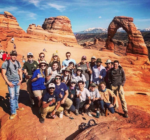 Photo of traveling field camp group in front of Delicate Arch in Arches National Park, Utah. Photo by Matt Dorsey.