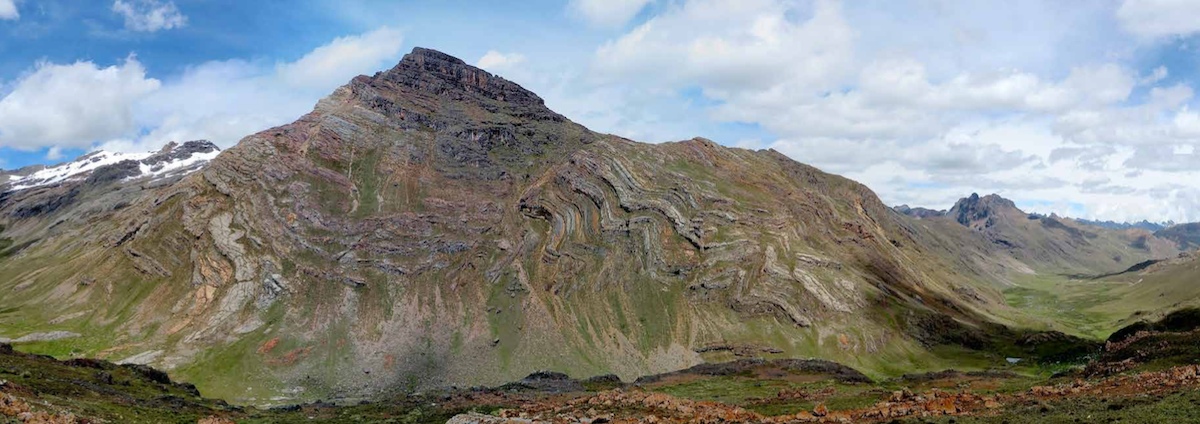 Landscape in the Eastern Cordillera of the Andes, southern Peru, showing folded Permian carbonates cut by a normal fault (dipping to the left). The snow-covered peaks (left background) were carried over rocks in the foreground by a reverse fault during Cenozoic shortening and construction of the Andes. (Photo courtesy of Dr. Nick Perez.)