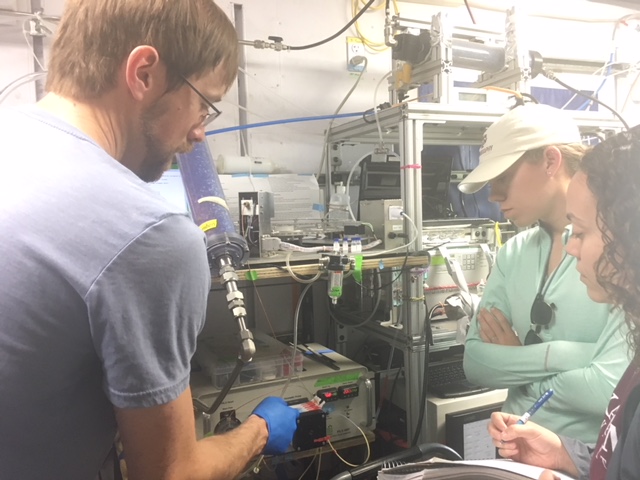 Brianna Hendrickson and Alyssa Alsante learning how to use the University of California, Irvine Particle into Liquid Sampler (PILS) Instrument (Photo courtesy of Dr. Sarah Brooks.)