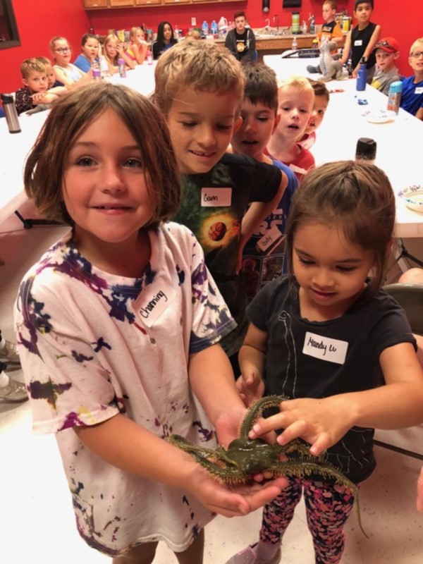 Students touching a brittle starfish (Photo courtesy of the Children’s Museum of the Brazos Valley.)