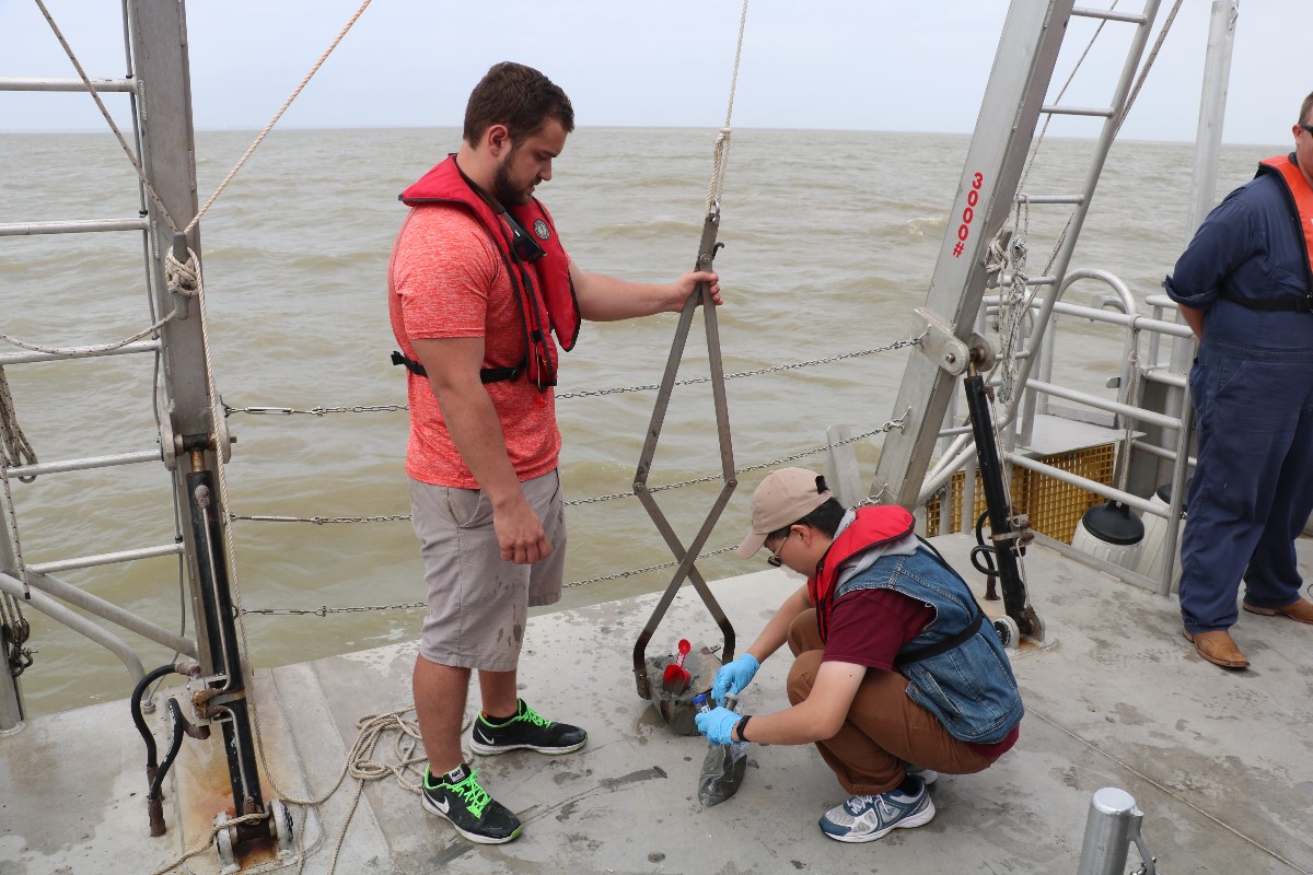 Graduate student, Damian Simonini (left) from the Department of Oceangoraphy, and Jerry Chen (right), from Department of Civil Engineering, collecting sediment sample from grab. (Photo by: Bumsoo Kim)