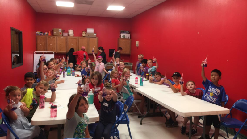 Students learning ocean acidification using straws to blow carbon dioxide into a pH indicator during Dr. Katie Shamberger’s lecture. (Photo courtesy of the Children’s Museum of the Brazos Valley.)
