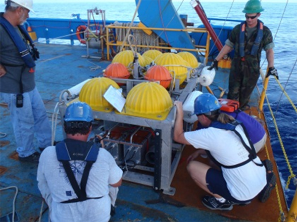 Students assist in preparing equipment for sampling on the R/V Brooks McCall, during an experiment mimicking a deep spill.