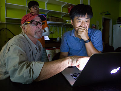 Texas Sea Grant Extension Agent Tony Reisinger and Dr. Jinha Jung attempting to identify red tide blooms. Photo by Seth Patterson.