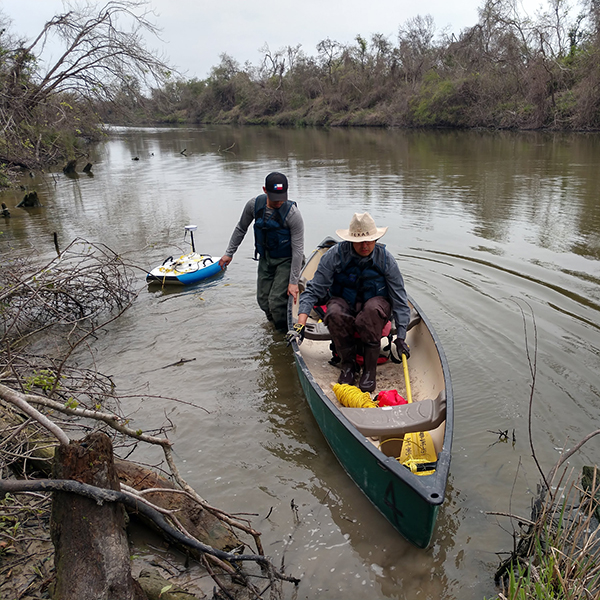 Cesar Castillo and undergraduate researcher Yair Torres (left), preparing to conduct a bathymetric survey of a river channel. (Photo courtesy of Cesar Castillo.)