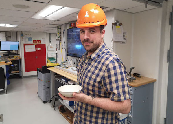 John Sarao in the core description area of Expedition 385. He is on his way to collect paleo-sediment core samples from the core catcher on deck. (Photo credit: Florian Schubert.)