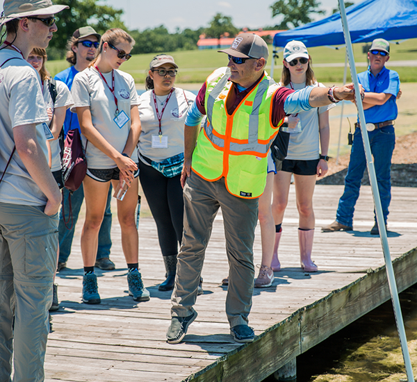 Dr. Stacey Lyle (center), assistant professor of practice geography, teaching GeoX 2019 participants field work techniques at the Triple JJJ Ranch. (Photo by the Texas A&M Foundation.)