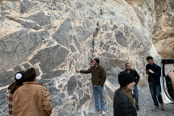 Students ponder the geologic origin of a large breccia outcrop with angular clasts suspended in a calcite matrix. Outcrop is located in Titus Canyon, Death Valley National Park, CA. (Photo courtesy of Dr. Brian Balta.)