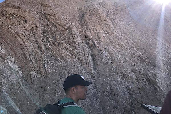 Student stands before chevron folds in Death Valley National Park, CA. (Photo courtesy of Dr. Brian Balta.)