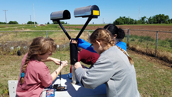 Undergraduate students Rachel Eldridge, Leanne Blind-Doskocil, and Erin Sherman (L to R) assembling the disdrometer. (Photo courtesy of Dr. Don Conlee.)