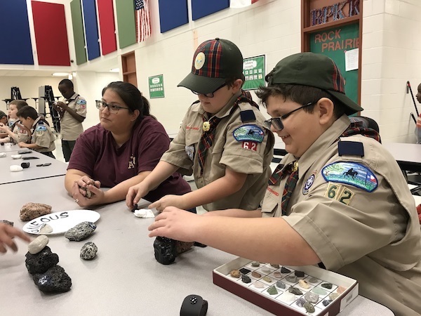 Two Webelos enjoy igneous rock samples with Michelle Chrpa. (Photo courtesy of Andrew Armstrong.)