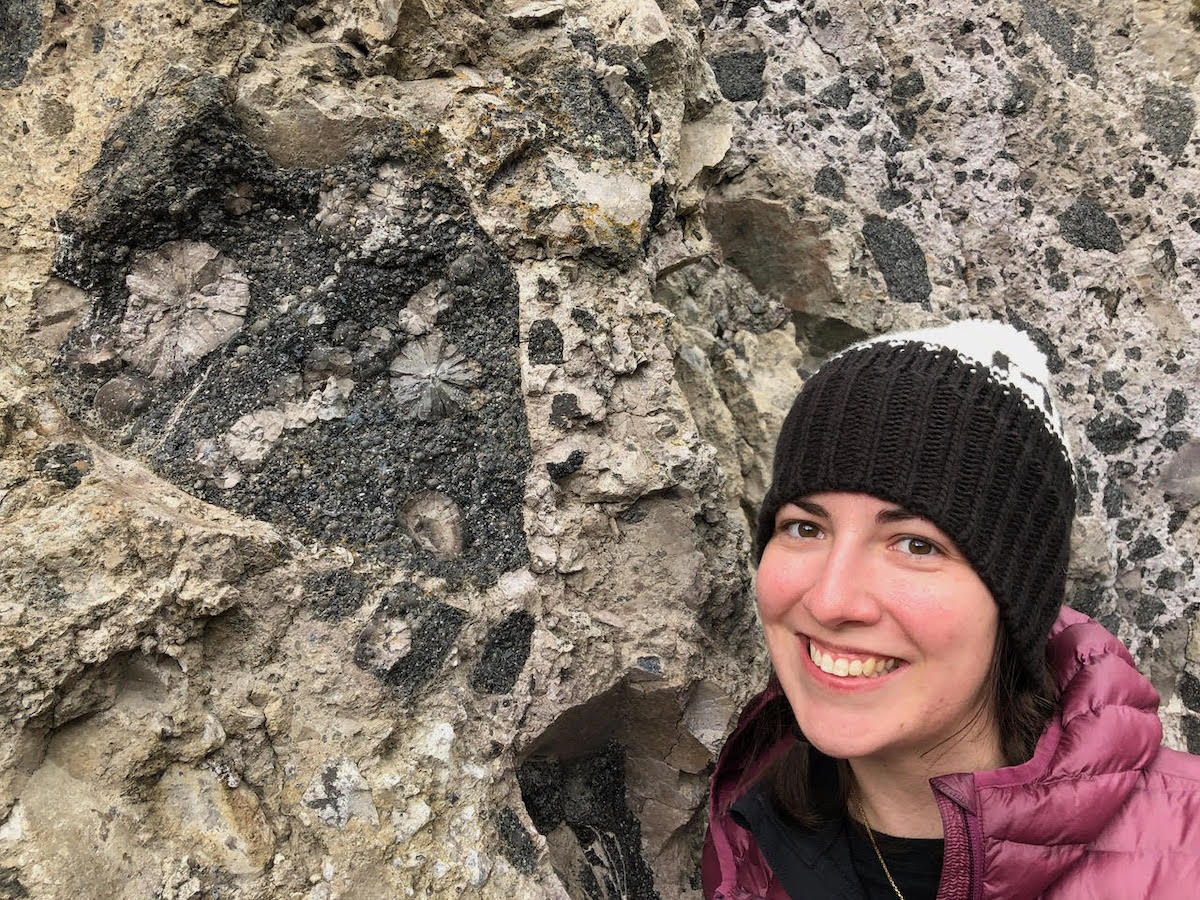 Dr. Kenderes poses next to an outcrop of spherulites in the Nez Perce Creek lava flow, a key stop while teaching field camp students about the geology of Yellowstone National Park, Wyoming. (Photo courtesy of Kenderes.)