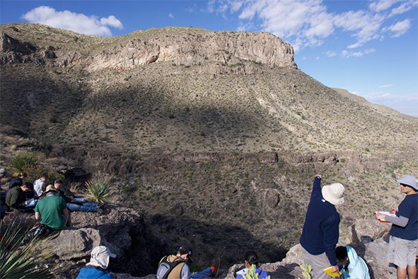 Dr. Mike Pope points out characteristic features of Mississippian mud mounds in the cliff face across the valley.