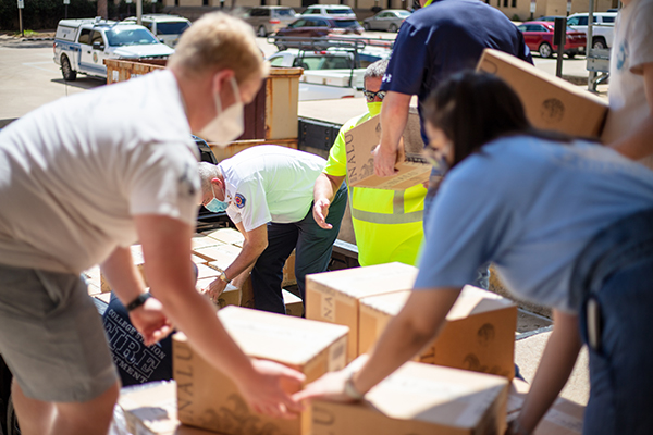 Texas A&M Geosciences students assist City of College Station and College Station Fire Department staff with loading water donations. (Photos by Leslie Lee.)