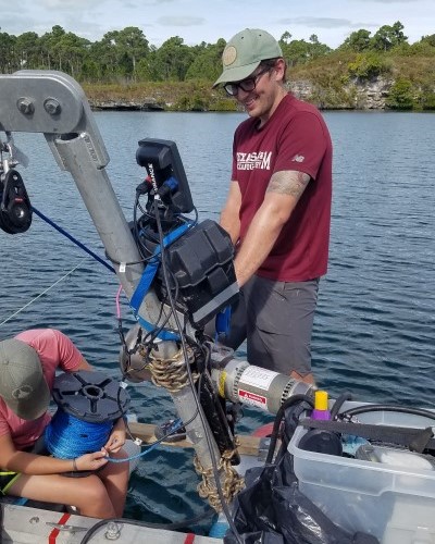 Collecting a sediment core on an inflatable raft in Drinkwater Sinkhole, Abacon, The Bahamas. (Photo by Nicole D'Entremont.)