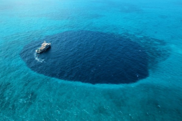 Drone imagery of the M/V Alucia sailing in Hine's Blue Hole on Cay Sal Bank, The Bahamas. (Photo by Pete van Hengstum.)