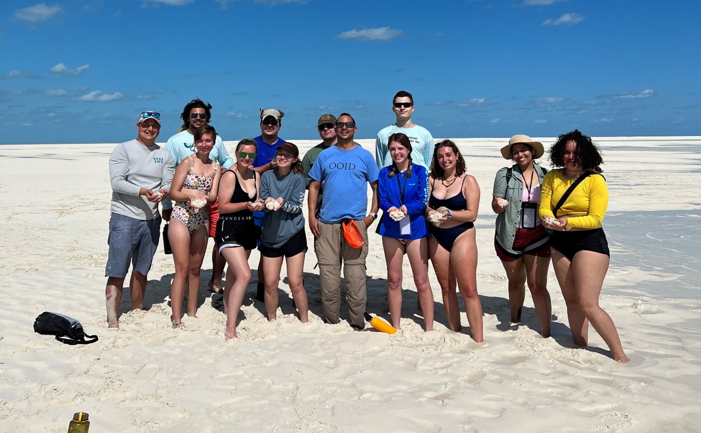 Examining ooilitic sand on the shoals of the Joulter Cays. From left to right: Dr. Cameron Manche,  Sam Queiroga, Milly Hencey,  Cameron Smolik, Elizabeth Mann, Danika Martin, Dr. Juan Carlos Laya, West Anderson, Lauren Telford, Dennis Zakowicz, Morgan Crowley, Barbara Reyes, and Bronte Heerdink.